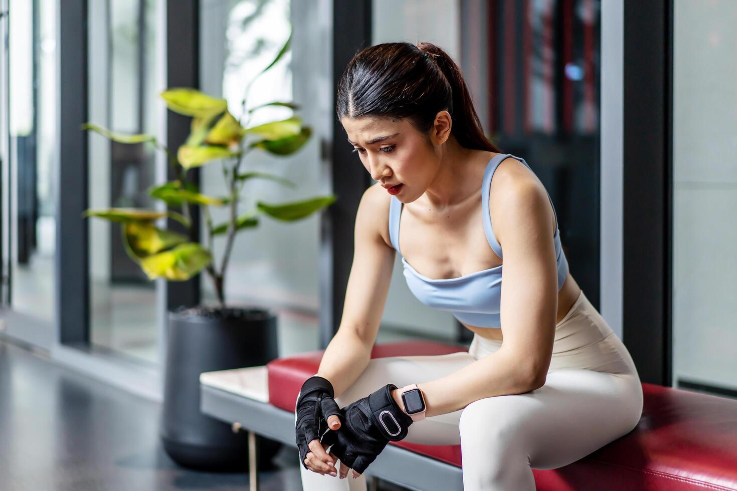 Portrait young asian woman in gym after workout, tired have sweaty and shortness of breath after physical training or exercise to burn energy, build muscle strength on training class in fitness. photo