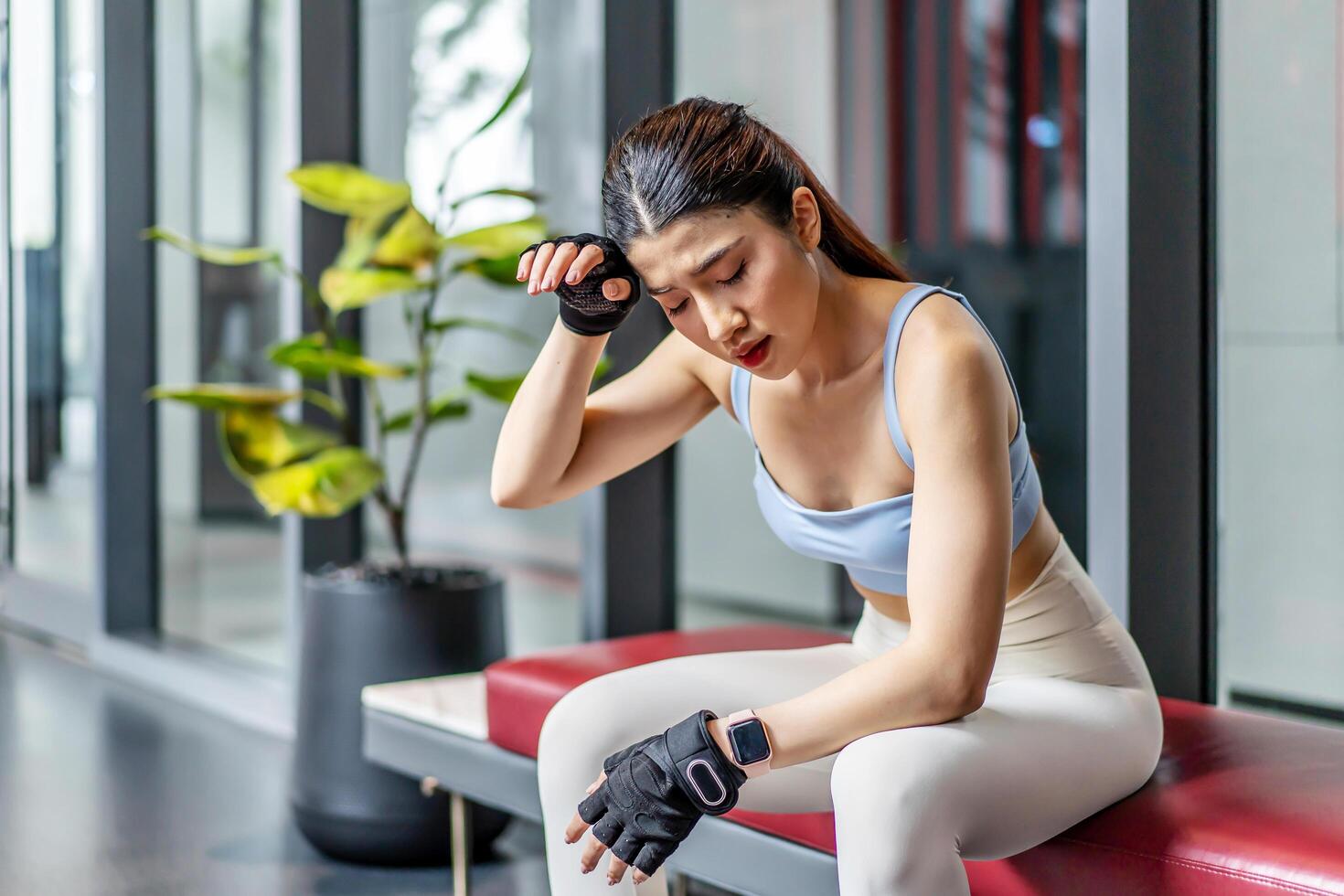 Portrait young asian woman in gym after workout, tired have sweaty and shortness of breath after physical training or exercise to burn energy, build muscle strength on training class in fitness. photo