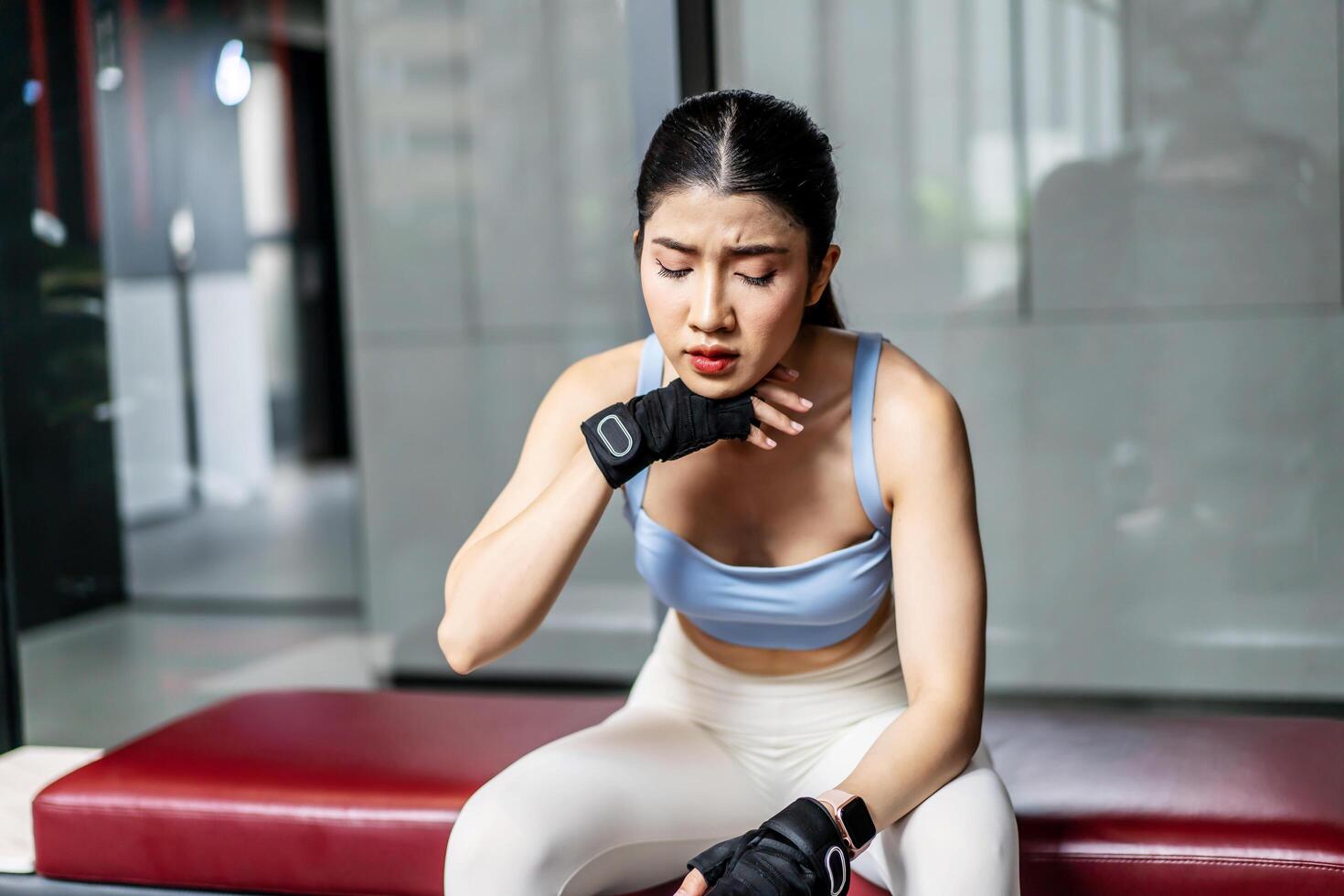 Portrait young asian woman in gym after workout, tired have sweaty and shortness of breath after physical training or exercise to burn energy, build muscle strength on training class in fitness. photo
