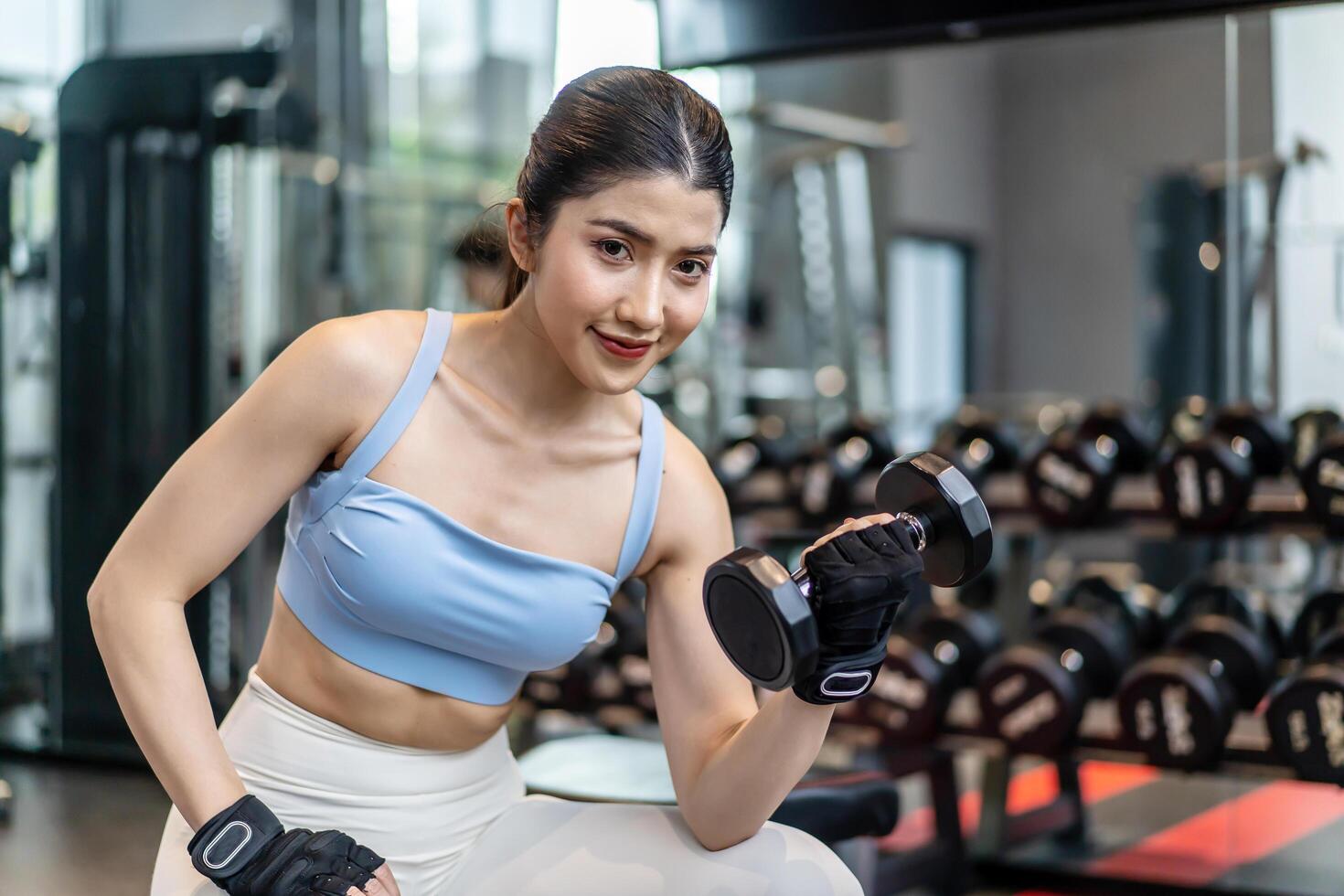 Weights training, Young asian woman lifting weights with equipment in the background, Sportswear girl workout with strong beautiful fit body shape, Asia lifestyle with copy space photo