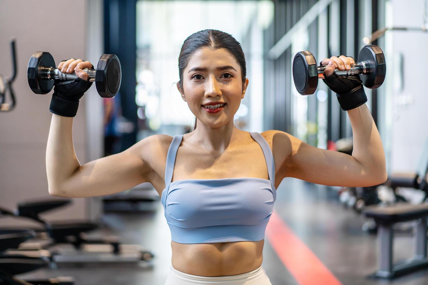 Weights training, Young asian woman lifting weights with equipment in the background, Sportswear girl workout with strong beautiful fit body shape, Asia lifestyle with copy space photo