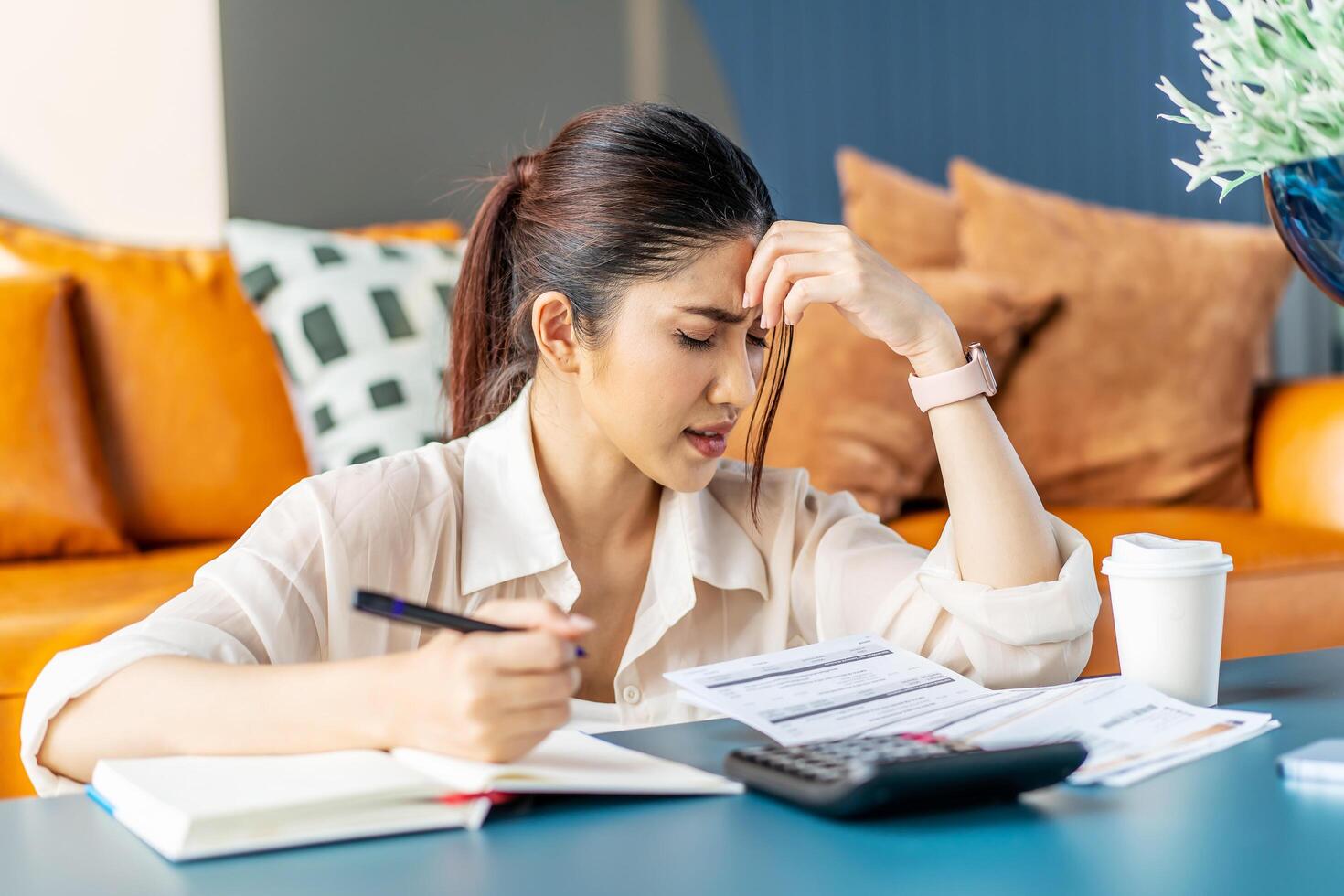 Upset asian woman sit at desk do accounting job or manage personal finances, reviewing bills feels upset due huge taxes, sum need to pay, experiences lack of money, crisis, bankruptcy concept photo