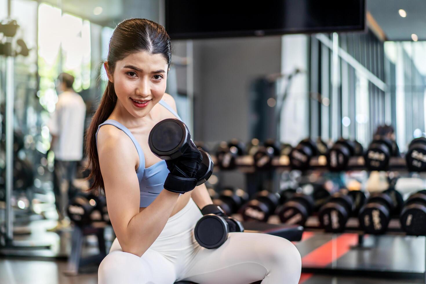 Weights training, Young asian woman lifting weights with equipment in the background, Sport ware girl workout with strong beautiful fit body shape, Asia lifestyle with copy space photo