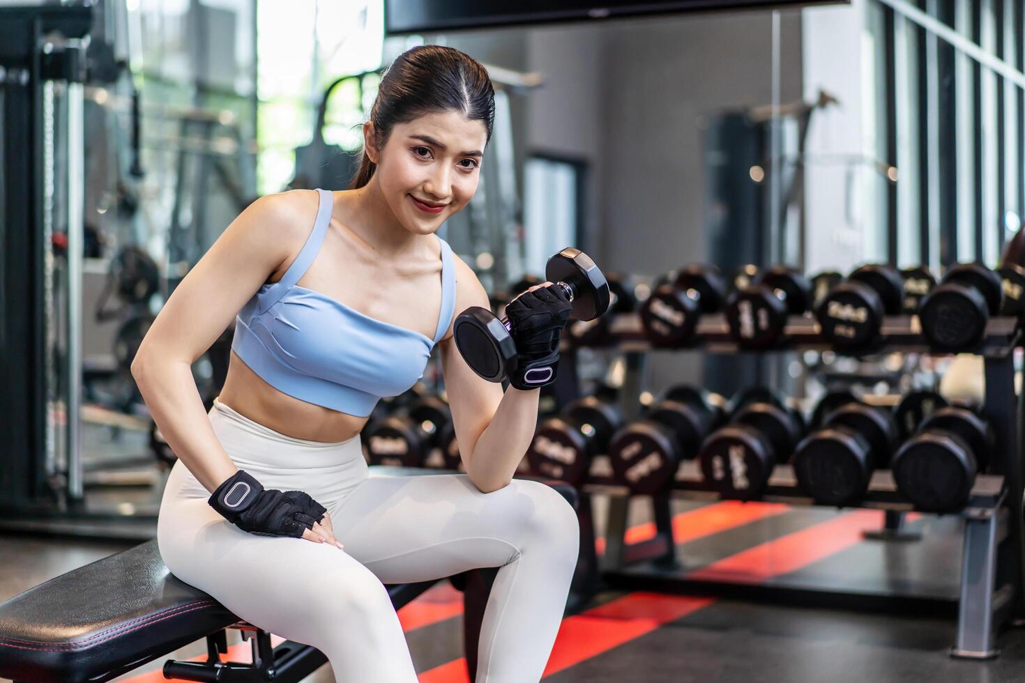 Weights training, Young asian woman lifting weights with equipment in the background, Sportswear girl workout with strong beautiful fit body shape, Asia lifestyle with copy space photo