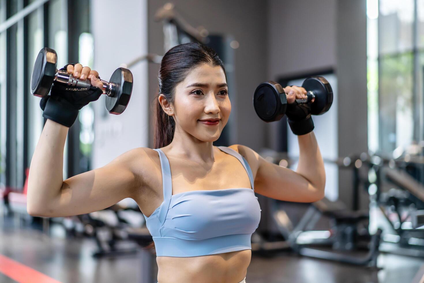 Weights training, Young asian woman lifting weights with equipment in the background, Sportswear girl workout with strong beautiful fit body shape, Asia lifestyle with copy space photo