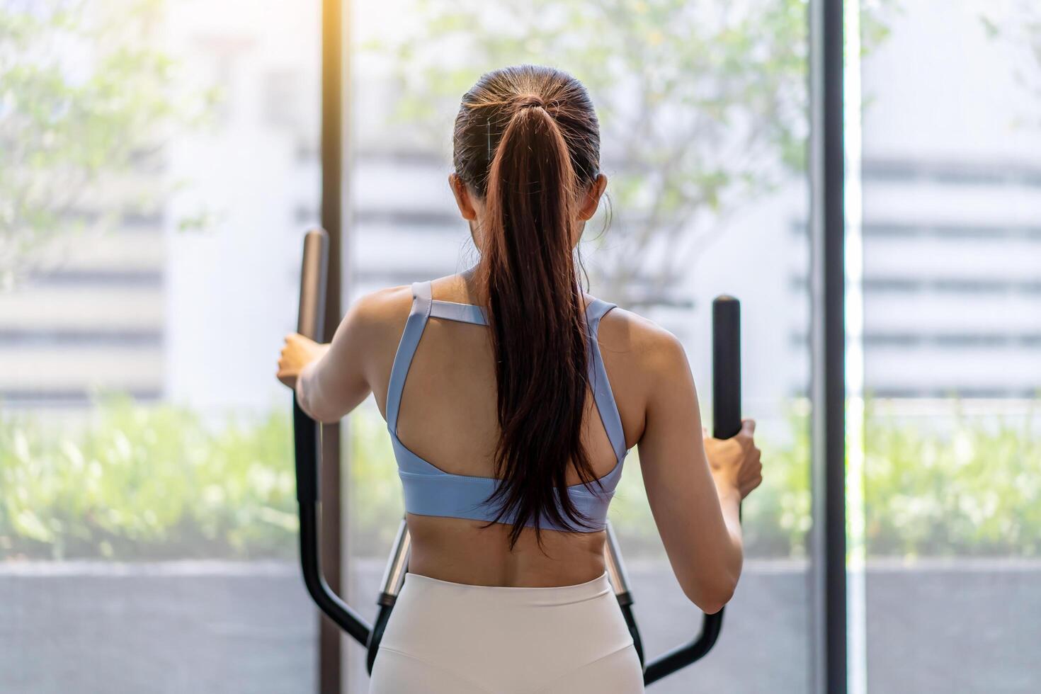 Young asian girl jogging on a treadmill in a gym, Muscular athletes actively training in the gym, Female training at fitness center. Woman exercising cardio workout, exercise lose weight photo