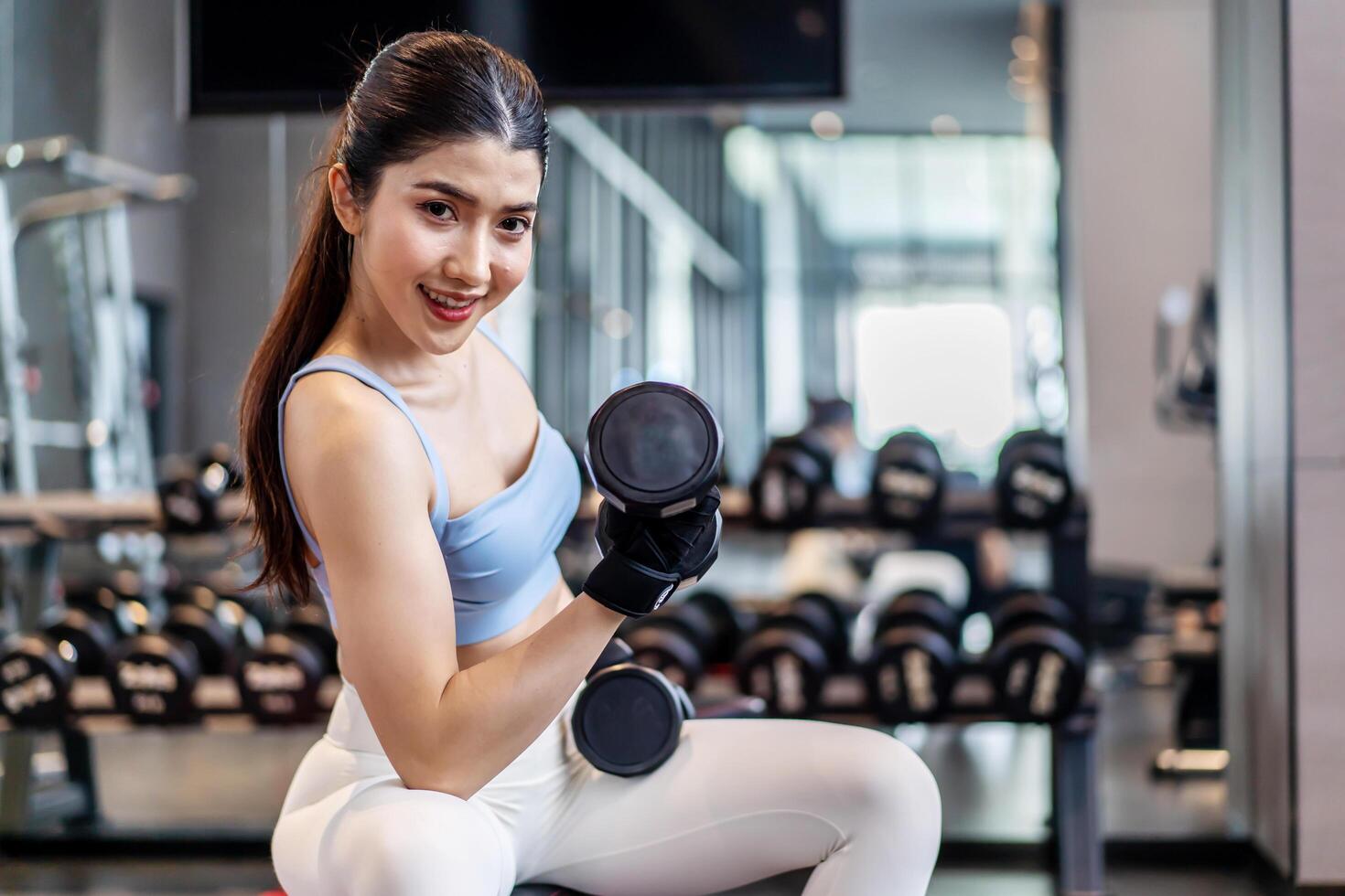 Weights training, Young asian woman lifting weights with equipment in the background, Sport ware girl workout with strong beautiful fit body shape, Asia lifestyle with copy space photo