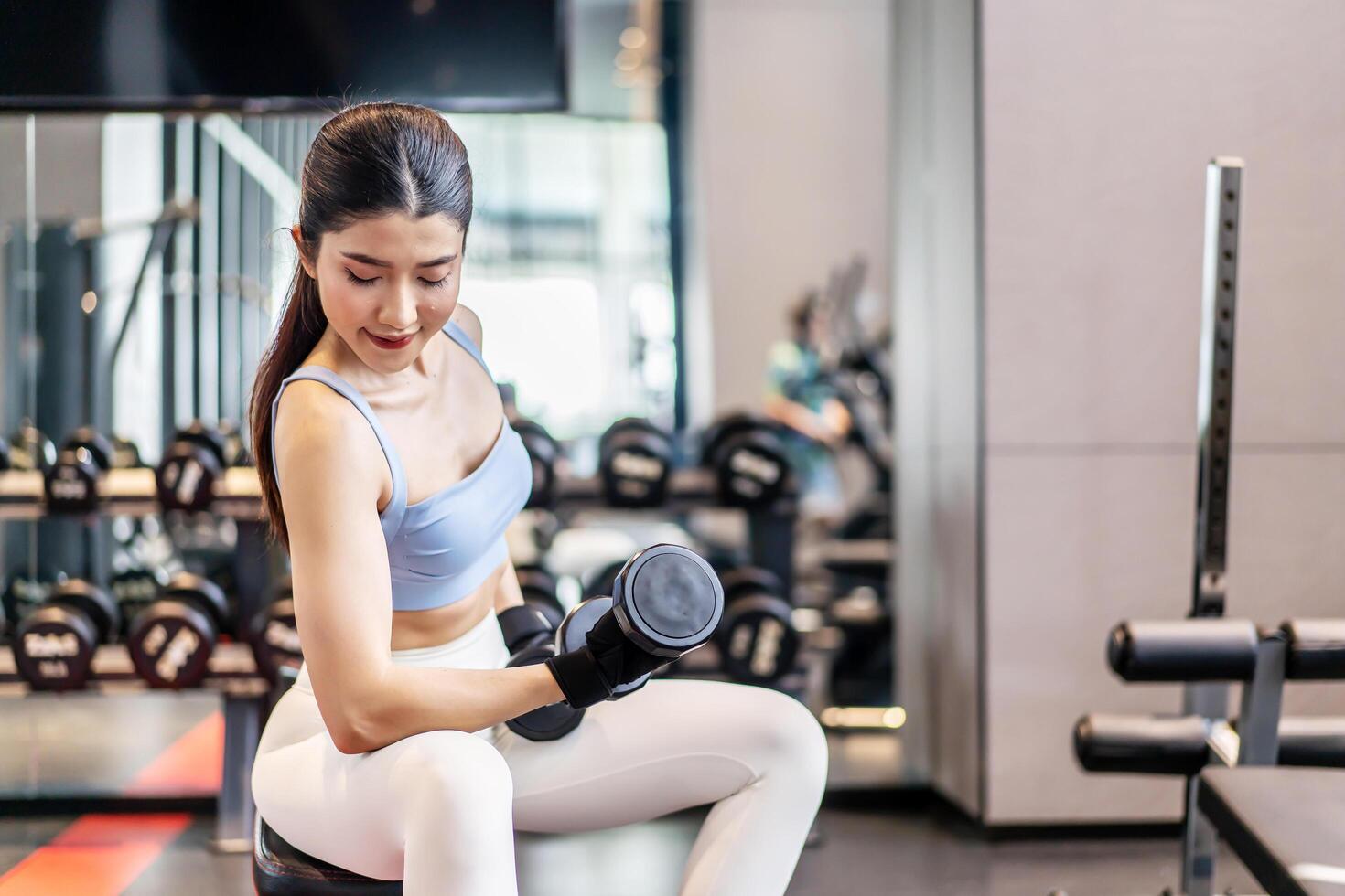 Weights training, Young asian woman lifting weights with equipment in the background, Sport ware girl workout with strong beautiful fit body shape, Asia lifestyle with copy space photo