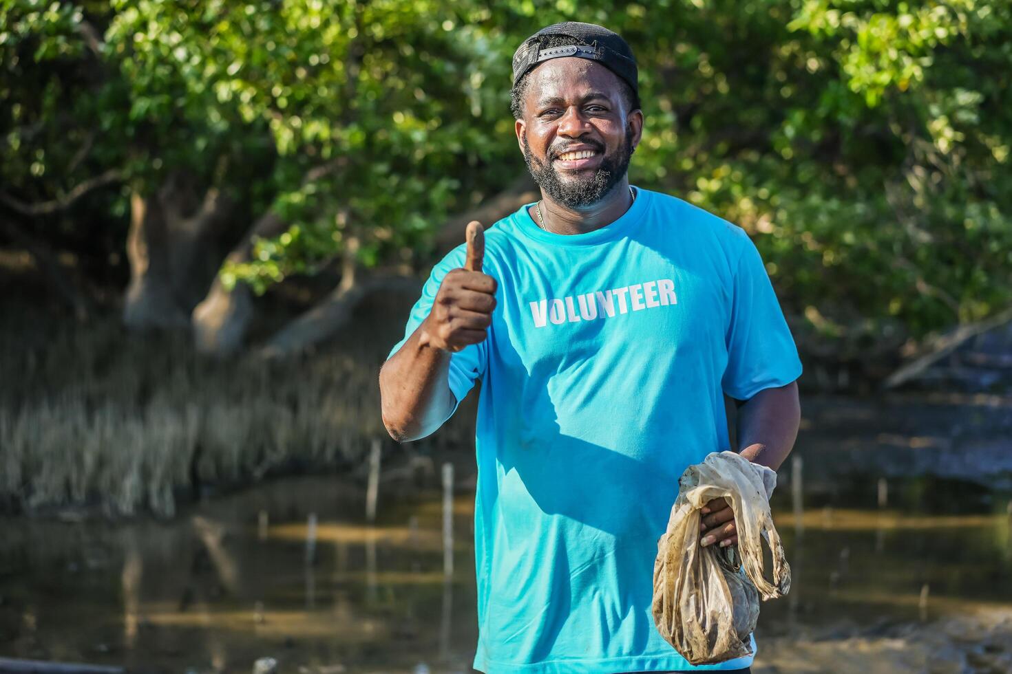 African American men volunteer thumbs up after helpers planting trees in mangrove forest for environmental protection and ecology, reduce global warming. photo