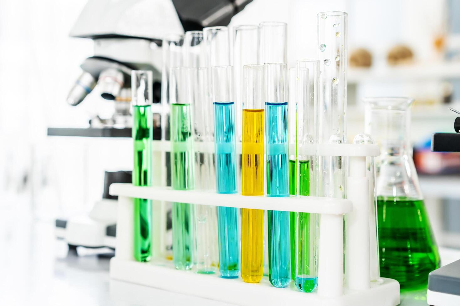 Colorful rows of laboratory or classroom test tubes and microscope with metal lens, Science and education. Scientific experiment, Researcher, Concept of medical or science laboratory, photo