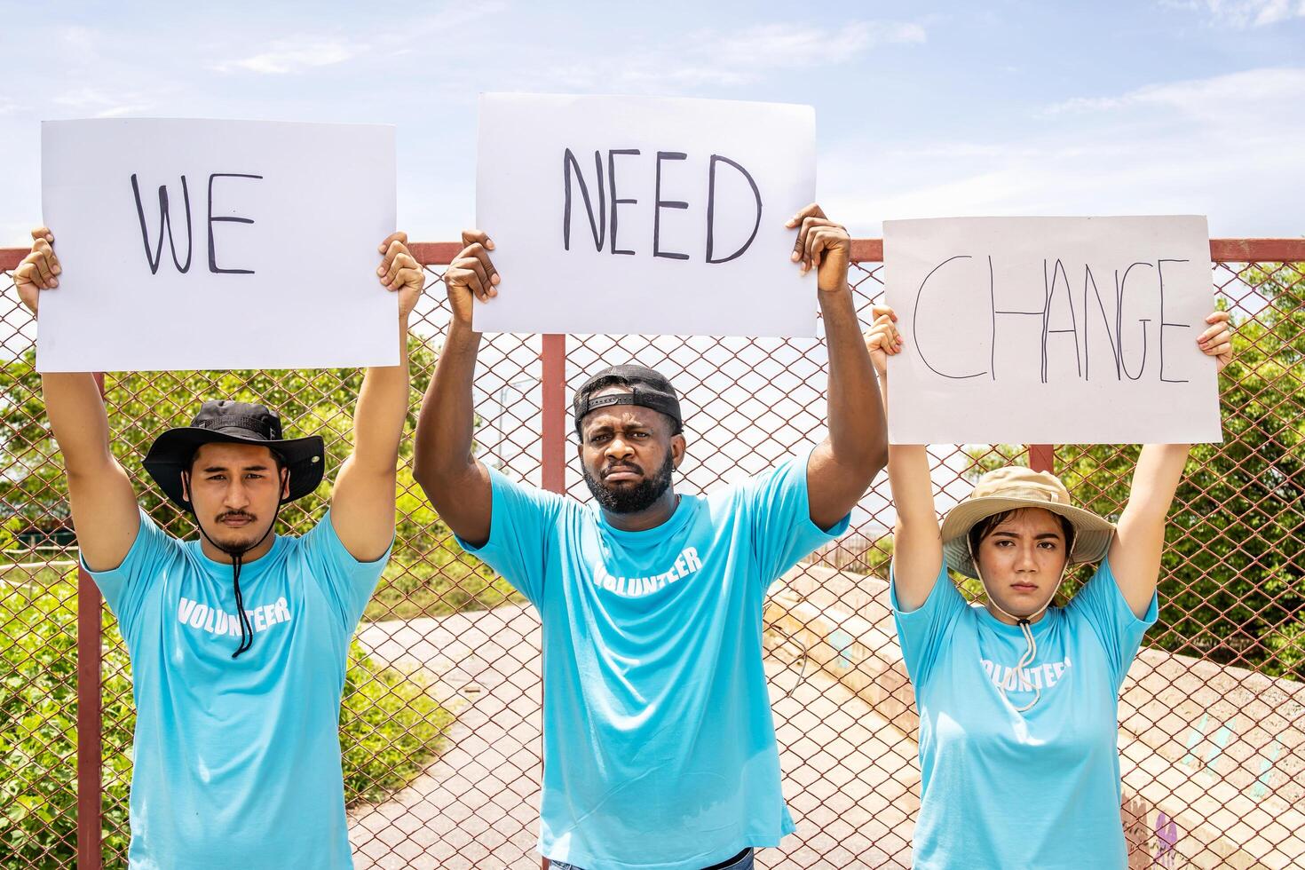 Three of people marched holding we need a change banner screaming proud, celebrating victory and success very excited with raised arms photo