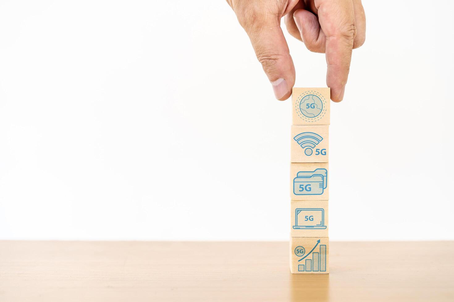 Businessman hand with wood cube block and icon symbol to 5G network high speed mobile internet new age network, mixed media, World wide business photo