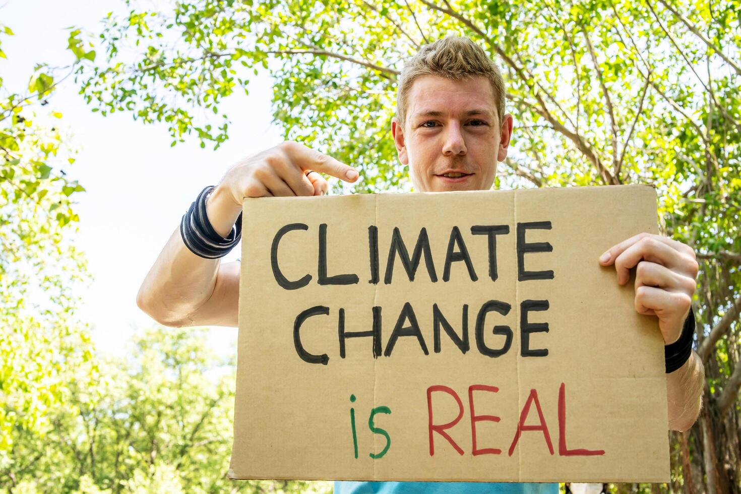 Protester holding sign Stop Climate Change. Man with placard at protest rally demonstration, strike against global warming. photo