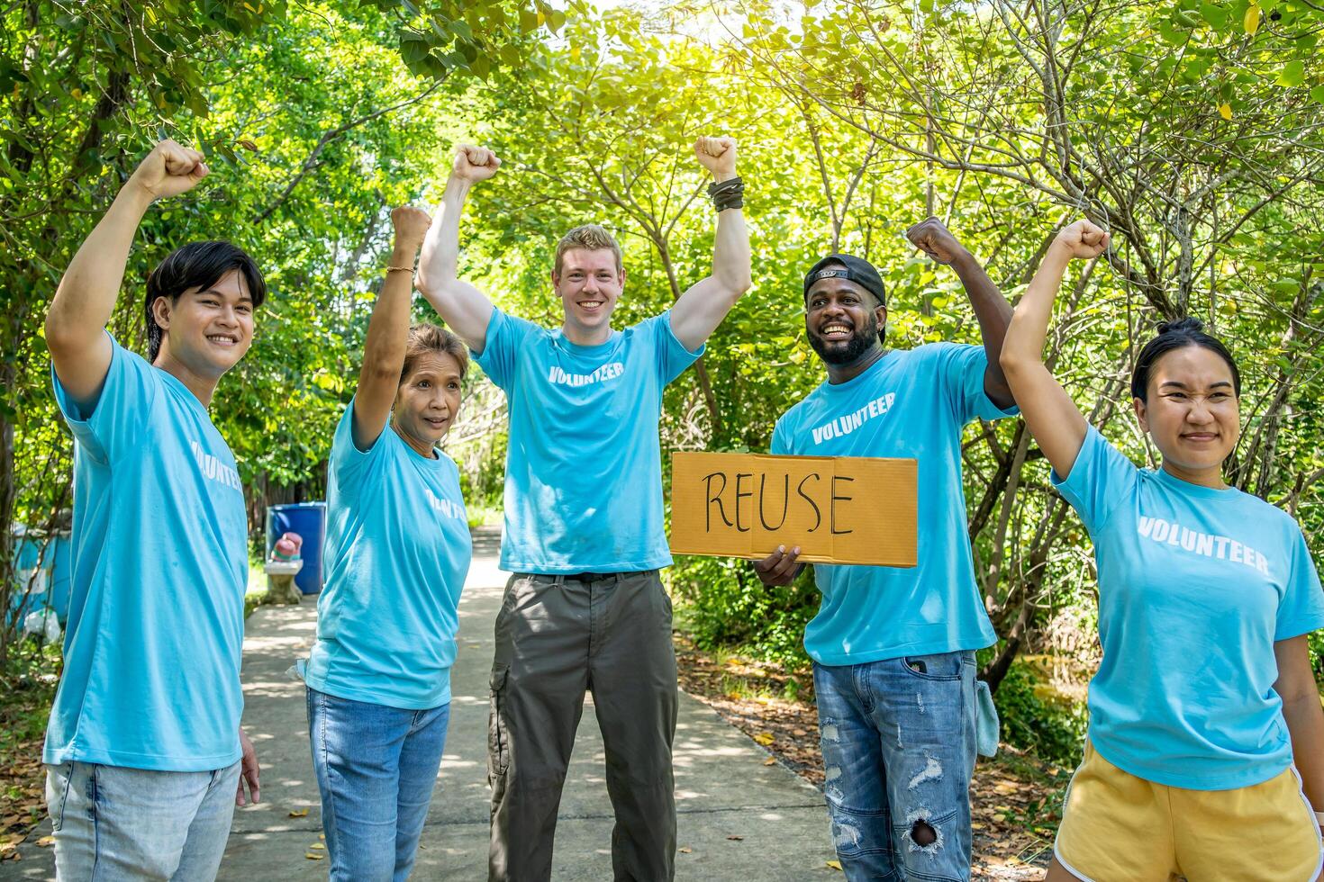 volunteering, charity, people, gesture and ecology concept - group of happy volunteers showing thumbs up and greeting you in park photo