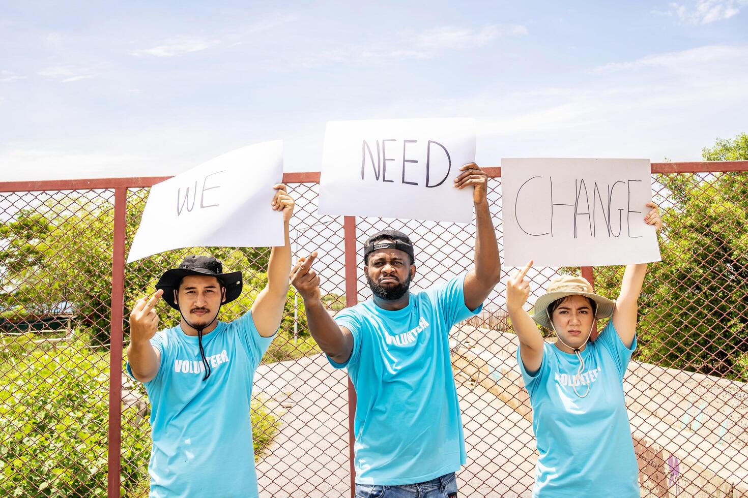 Three of people marched holding we need a change banner screaming showing middle finger doing you bad expression, provocation and rude attitude. Fresh Air photo