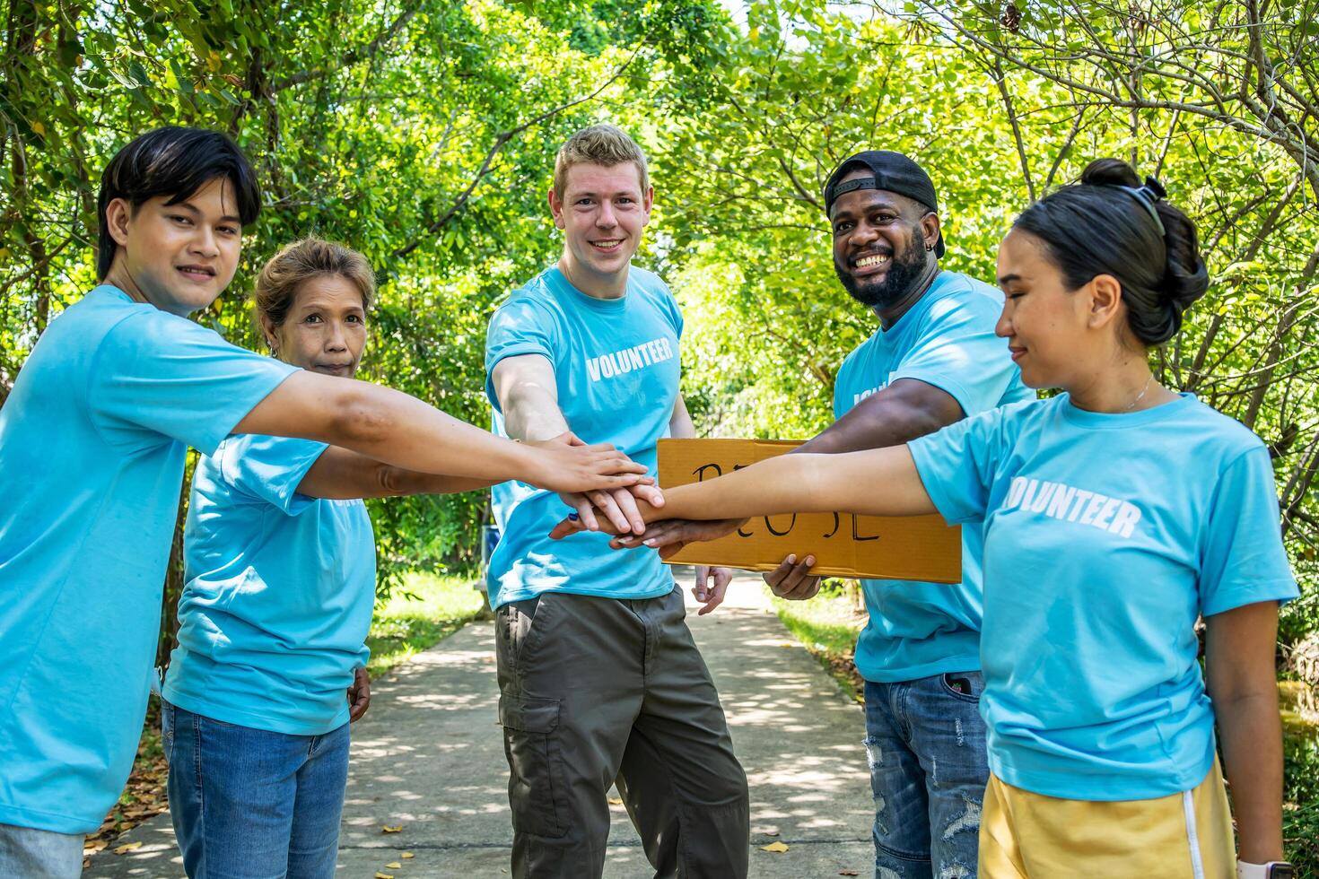 Group of volunteers stand to put your hands up and raise your hands together for help to save nature collecting garbage, Natural environment, pollution concept, Cleaning of nature from waste photo