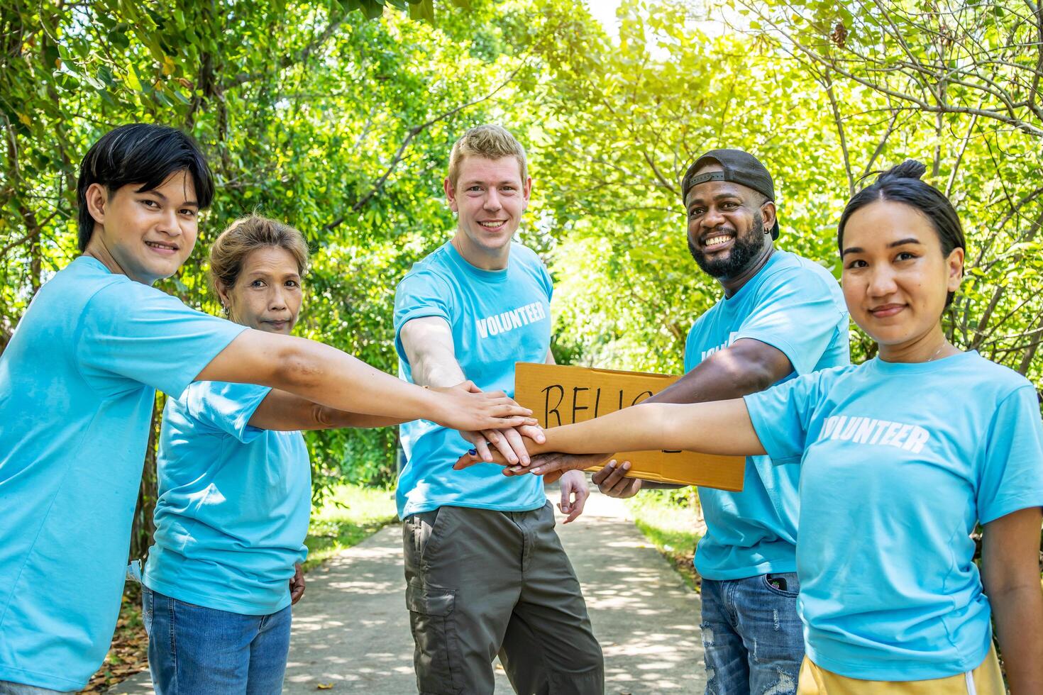 Group of volunteers stand to put your hands up and raise your hands together for help to save nature collecting garbage, Natural environment, pollution concept, Cleaning of nature from waste photo
