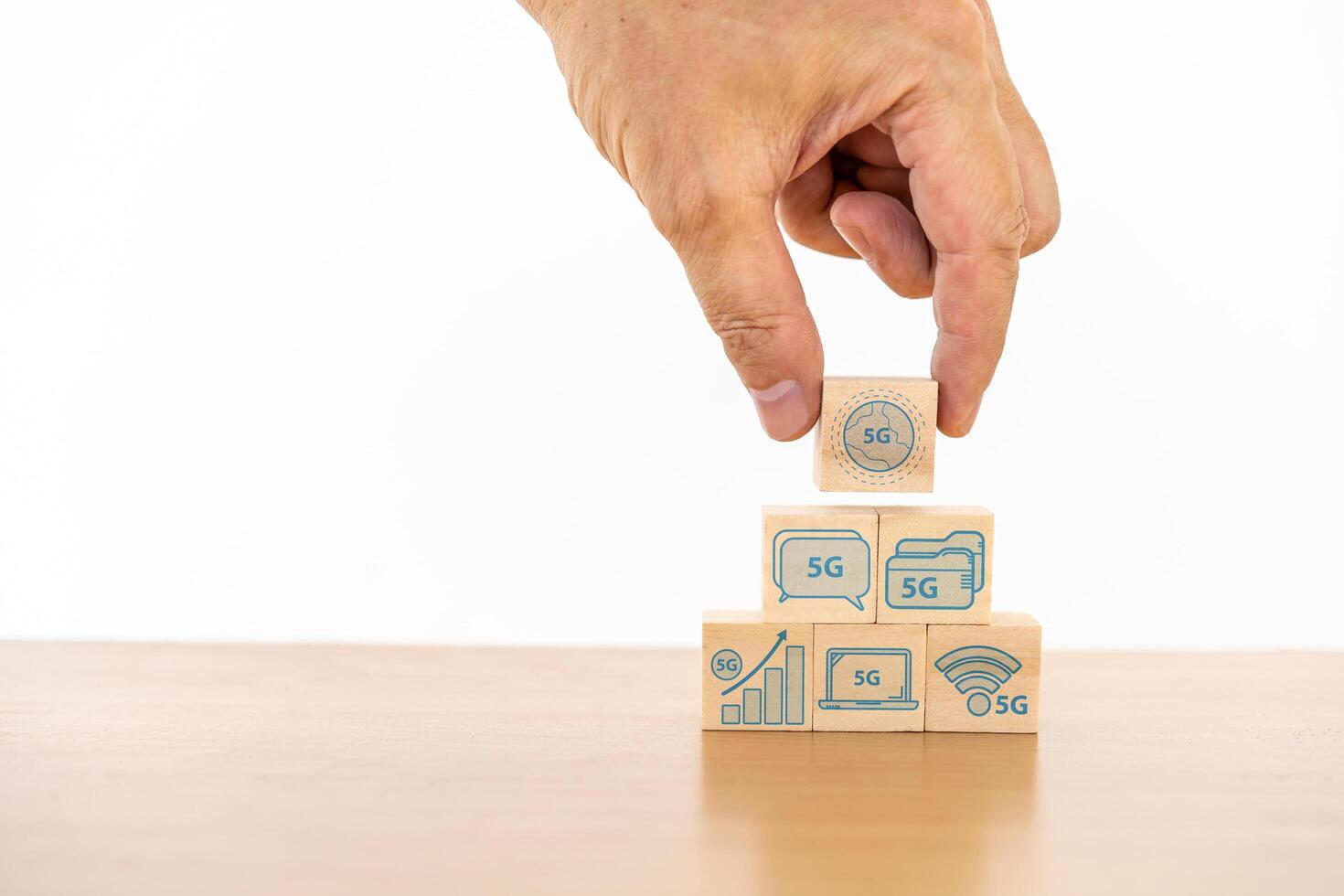 Businessman hand with wood cube block and icon symbol to 5G network high speed mobile internet new age network, mixed media, World wide business photo