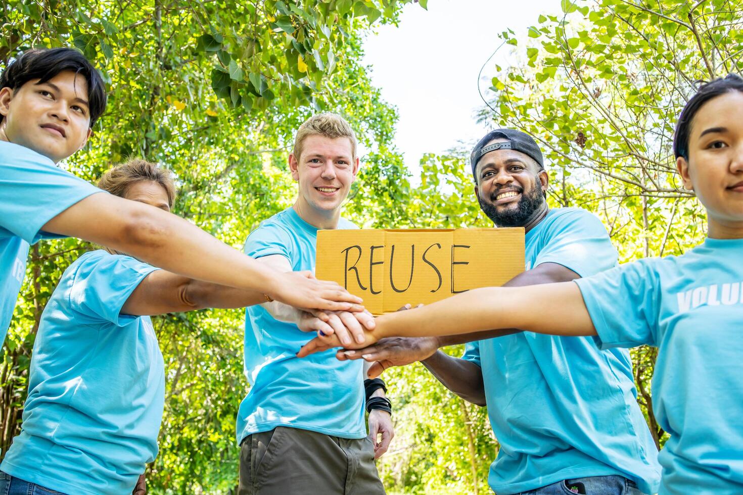 Group of volunteers stand to put your hands up and raise your hands together for help to save nature collecting garbage, Natural environment, pollution concept, Cleaning of nature from waste photo