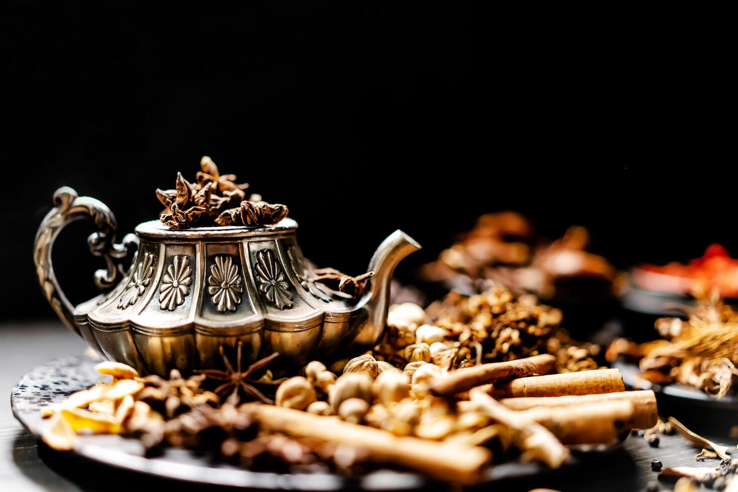 Assortment spices and seasonings with herbs on kitchen dark wooden table such as star anise, black pepper, cinnamon, bay leaf, for medicinal and herbal use in healing and cooking concept photo