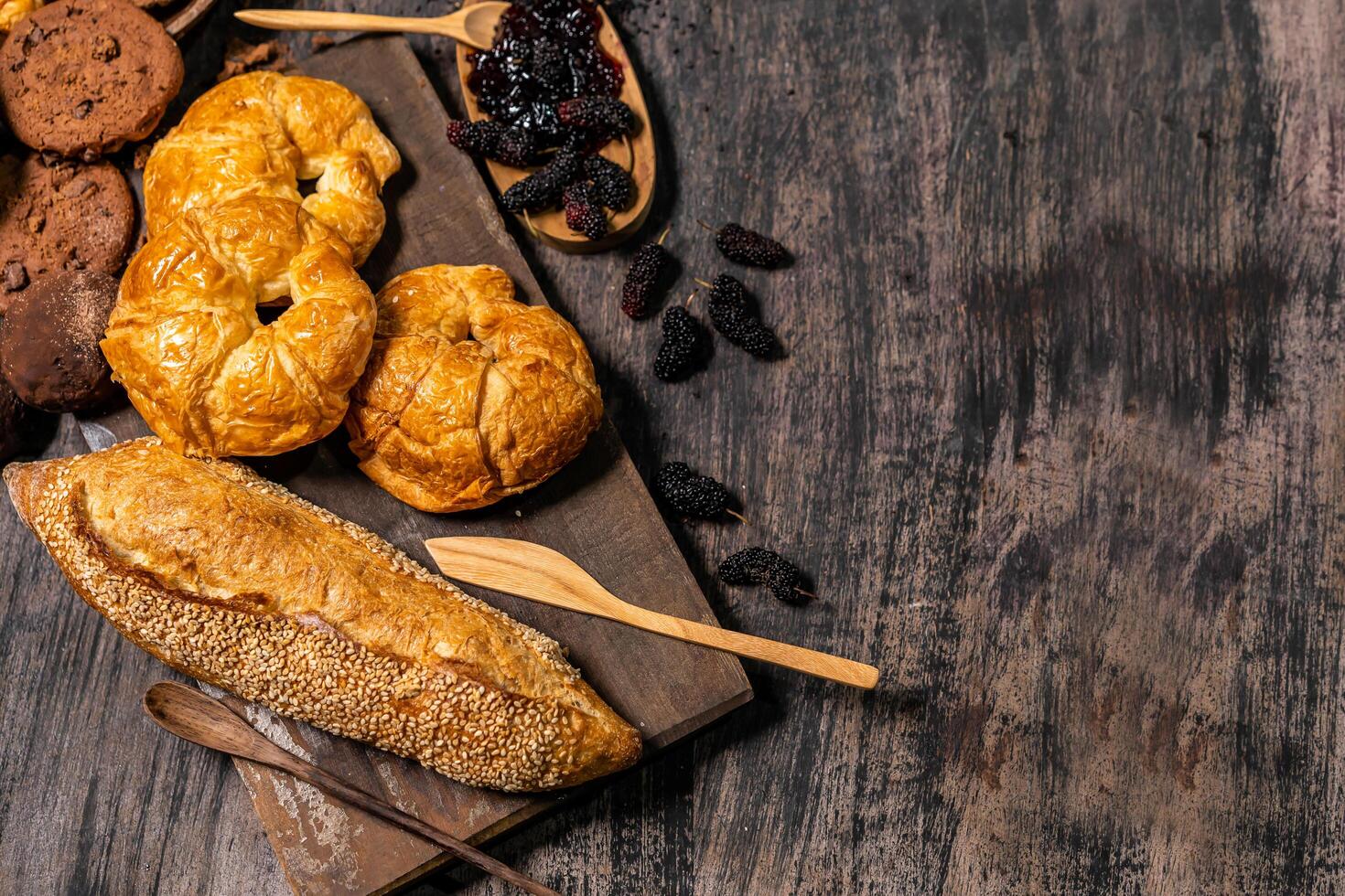 Top view of bread and loaf with cereals bread and bakery, breadsticks on wooden table in dark background with copy space photo