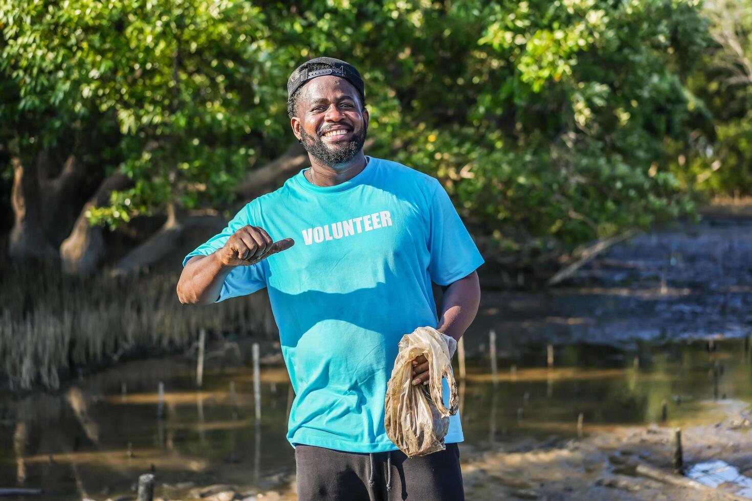 African American men volunteer showing the lettering on t-shirts together in partnership teamwork smiling look at the camera in forests, Environmental protection, and ecology concept. photo