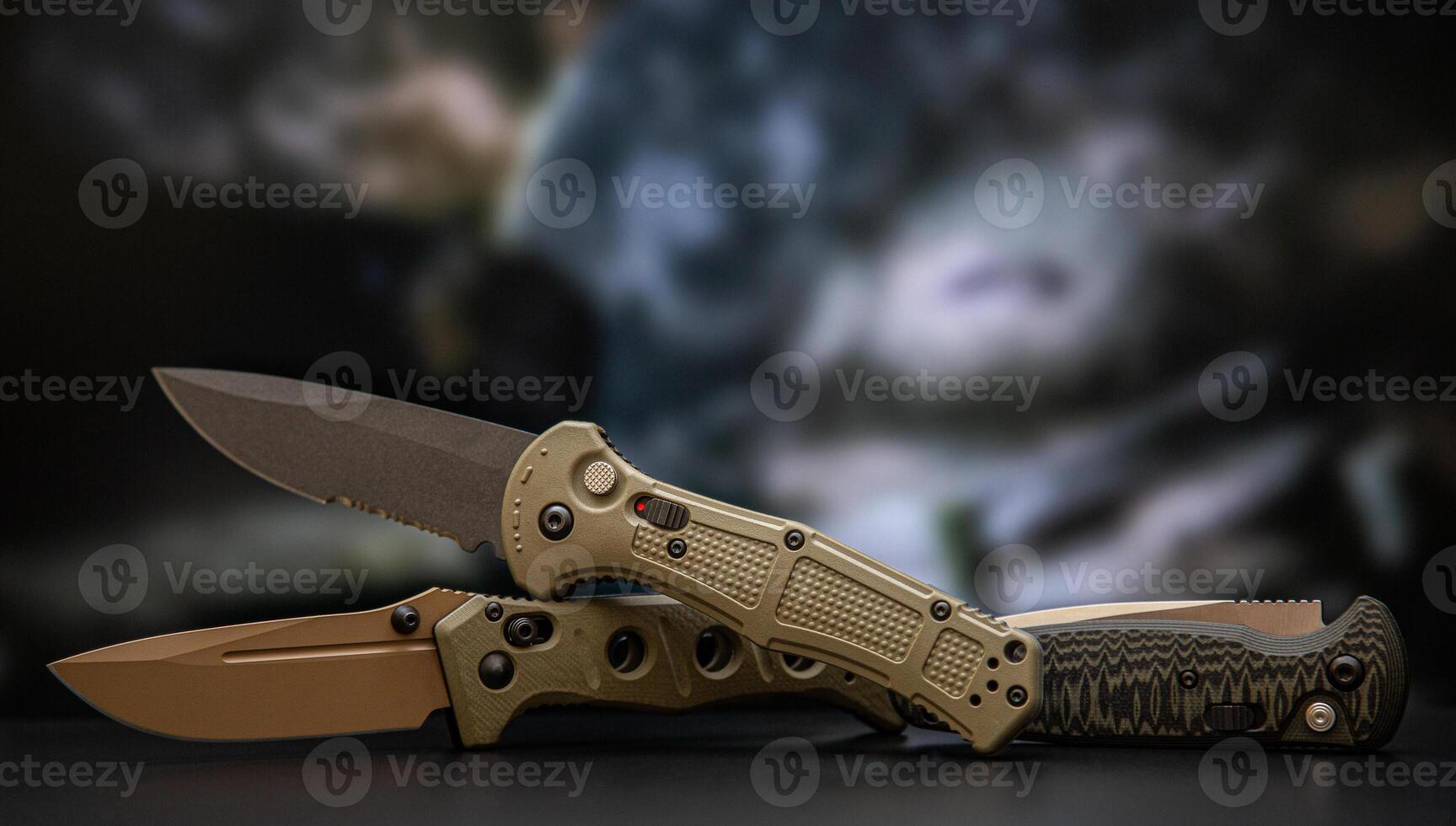 Khaki military pocket folding knives. Compact metal sharp knife with a folding blade. Blurred back. photo
