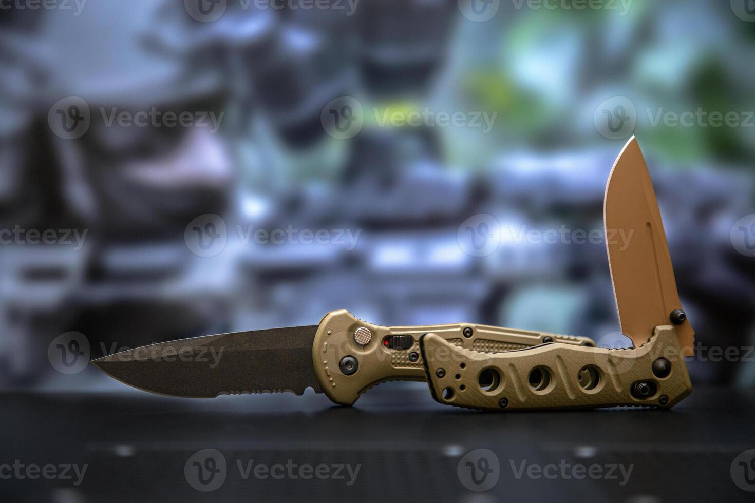 Khaki military pocket folding knives. Compact metal sharp knife with a folding blade. Blurred back. photo