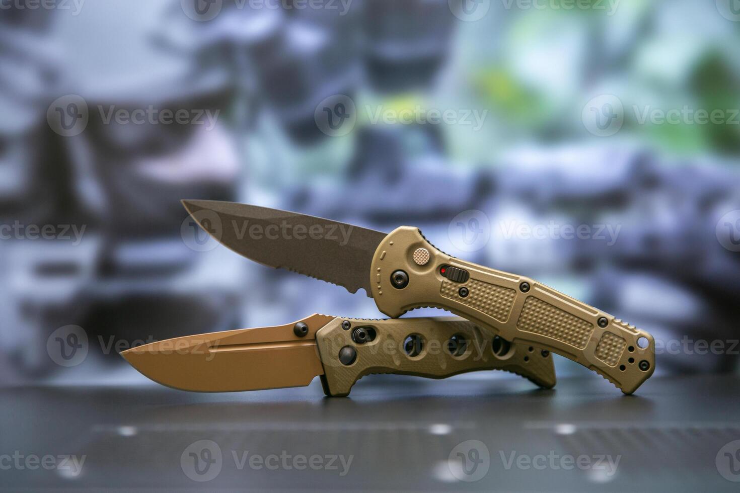 Khaki military pocket folding knives. Compact metal sharp knife with a folding blade. Blurred back. photo
