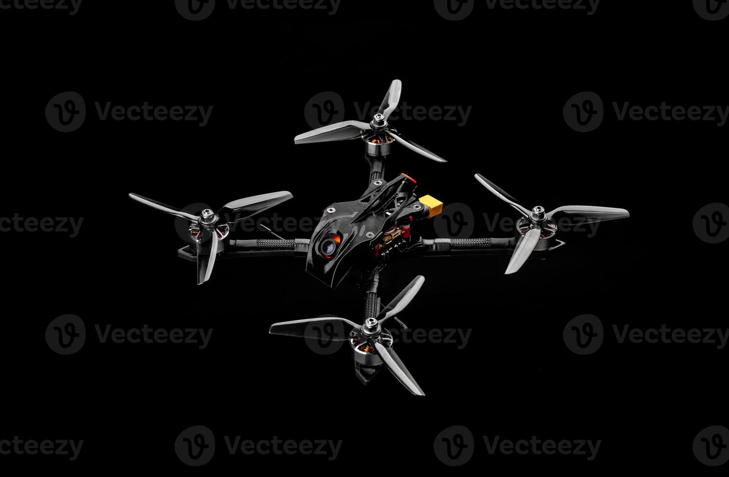 Modern FPV drone on a black background. Four-engine aircraft on the radio control. Drone for racing, filming and entertainment. photo