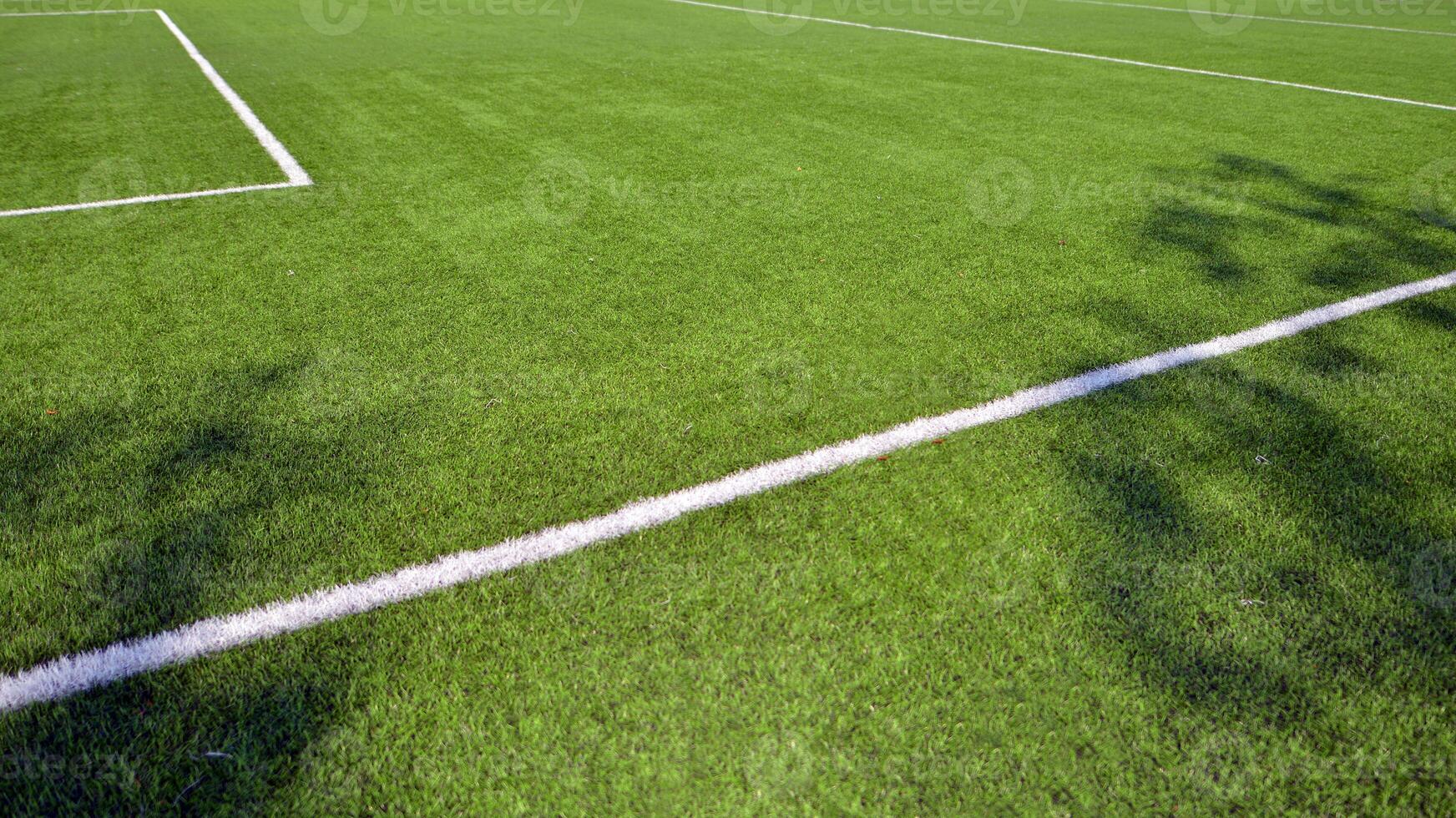 Artificial football turf with a white dividing line. Texture of Perfect green lawn on the football field. photo