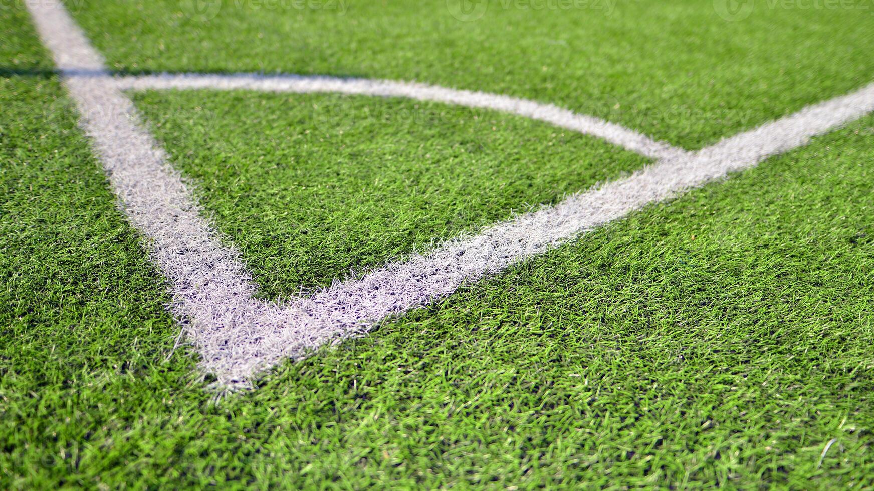 Artificial football turf with a white dividing line. Texture of Perfect green lawn on the football field. photo