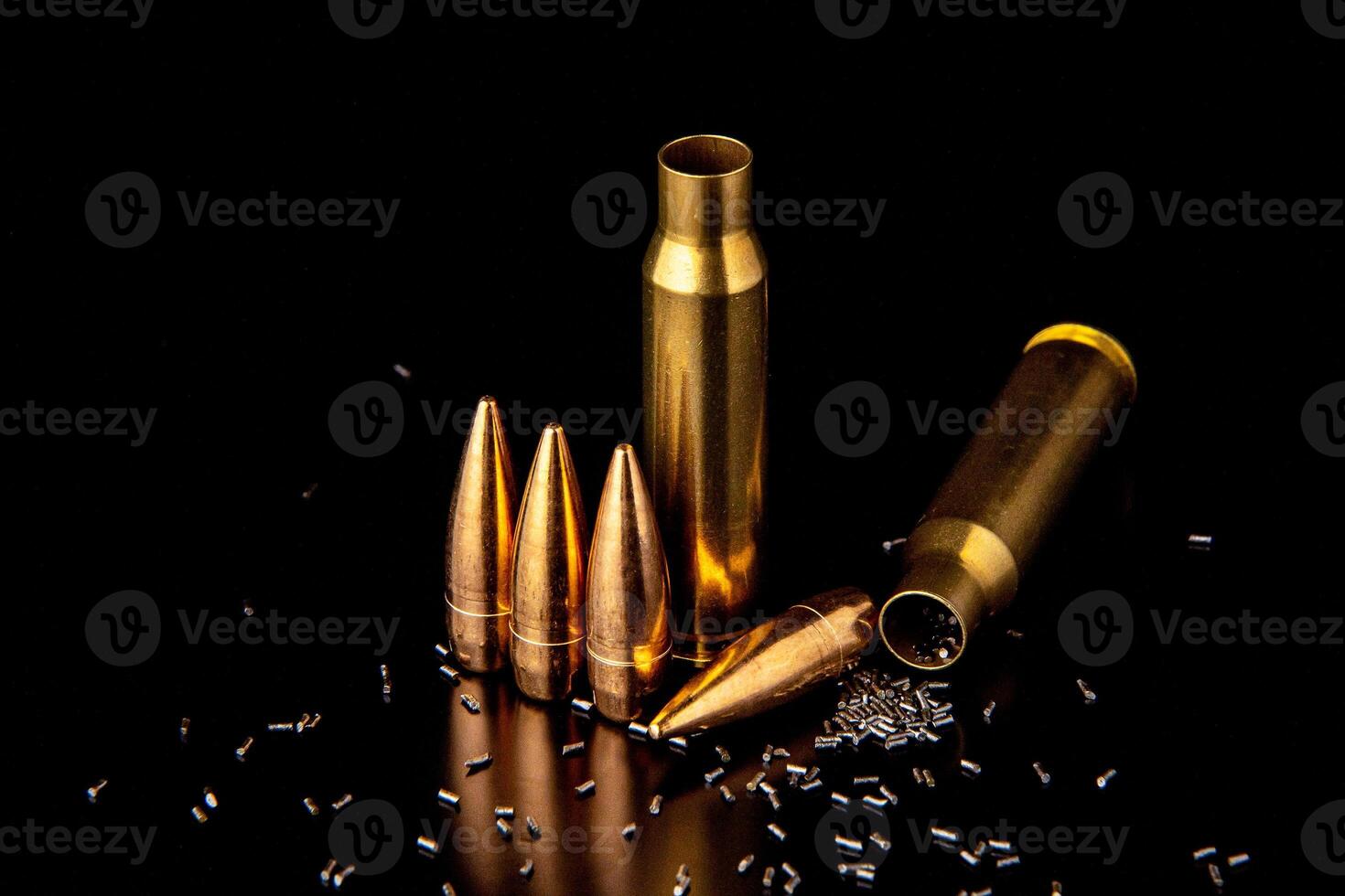 Close-up of disassembled rifle cartridges. Bullet isolated on black background with reflexion. Granulated gunpowder. photo