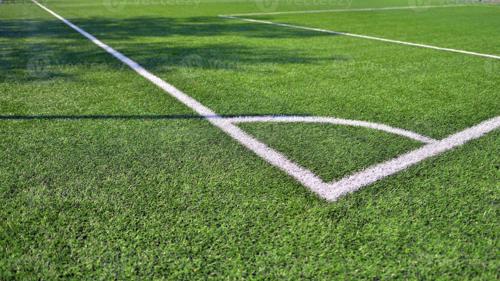 Artificial football turf with a white dividing line. Texture of Perfect green lawn on the football field. photo