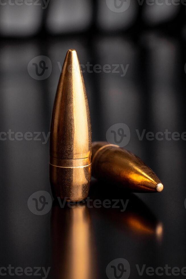 Bullet isolated on black background with reflexion. Rifle bullets close-up on black photo