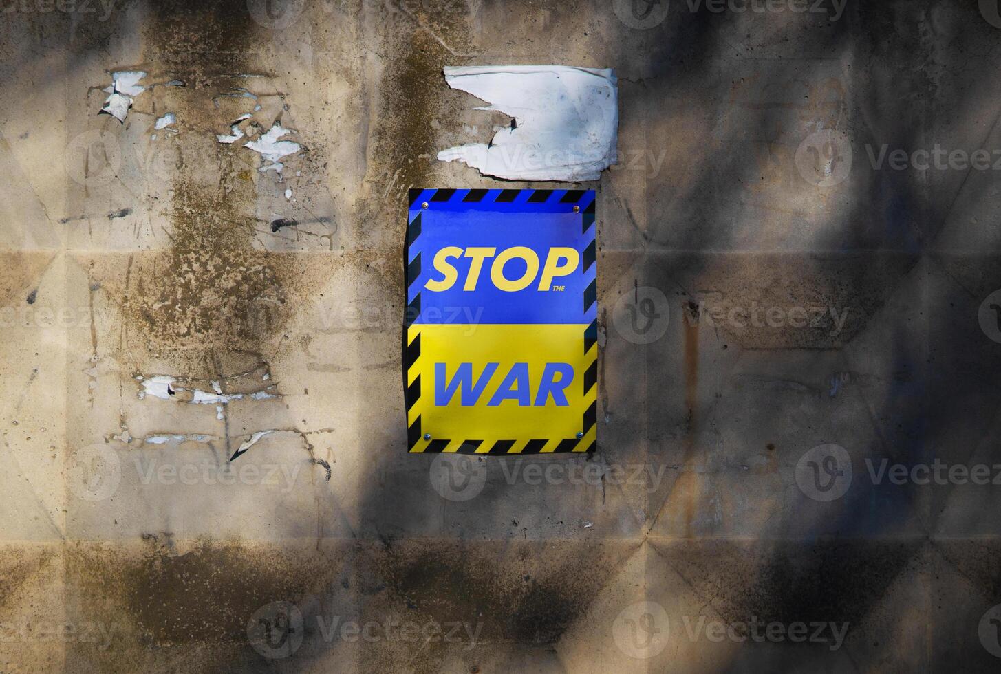 Poster stop the war on a yellow-blue sign in the colors of the flag of ukraine. Poster calling for peace on a concrete wall. photo