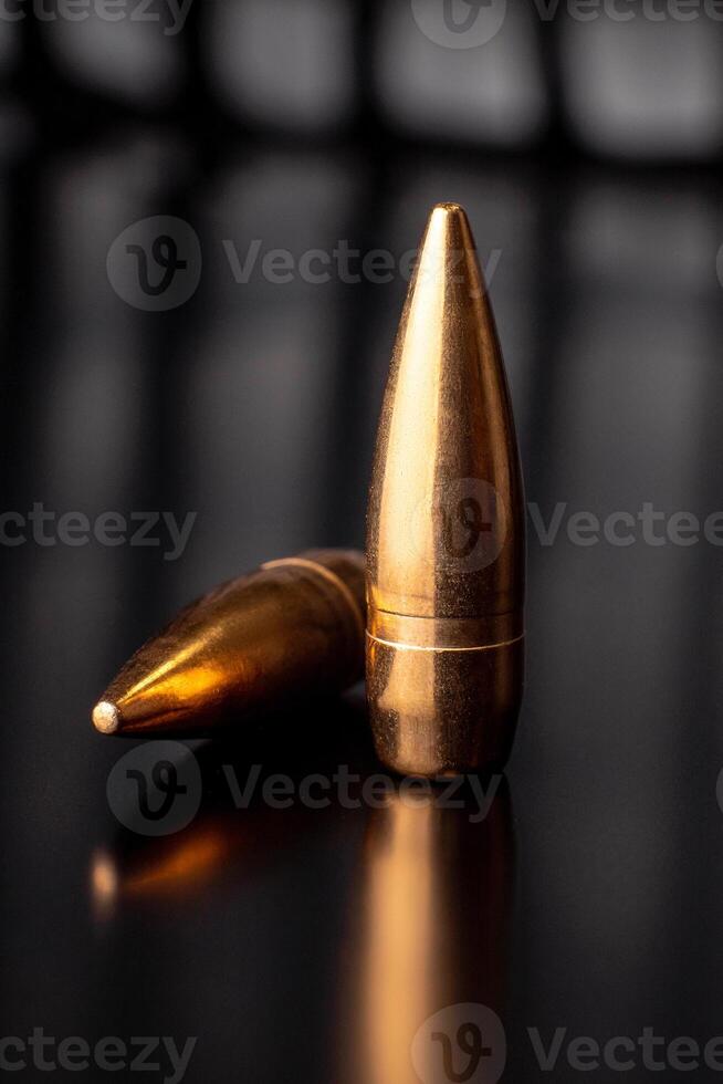 Bullet isolated on black background with reflexion. Rifle bullets close-up on black photo