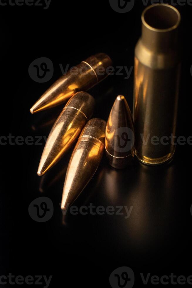 Bullet isolated on black background with reflexion. Rifle bullets close-up on black back. photo