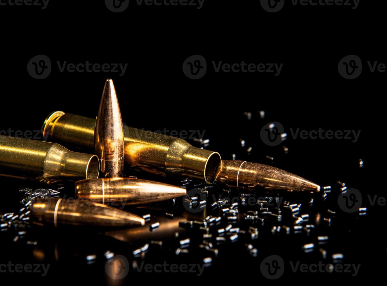 Close-up of disassembled rifle cartridges. Bullet isolated on black background with reflexion. Granulated gunpowder. photo