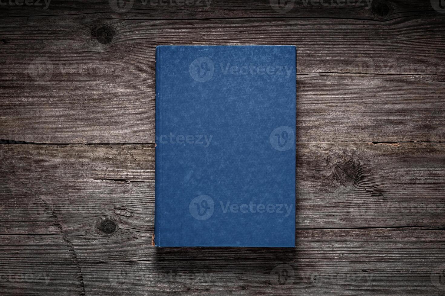 Closed book on vintage wooden background. Old book on the wooden table. Closed book with empty cover laying on wooden table. photo