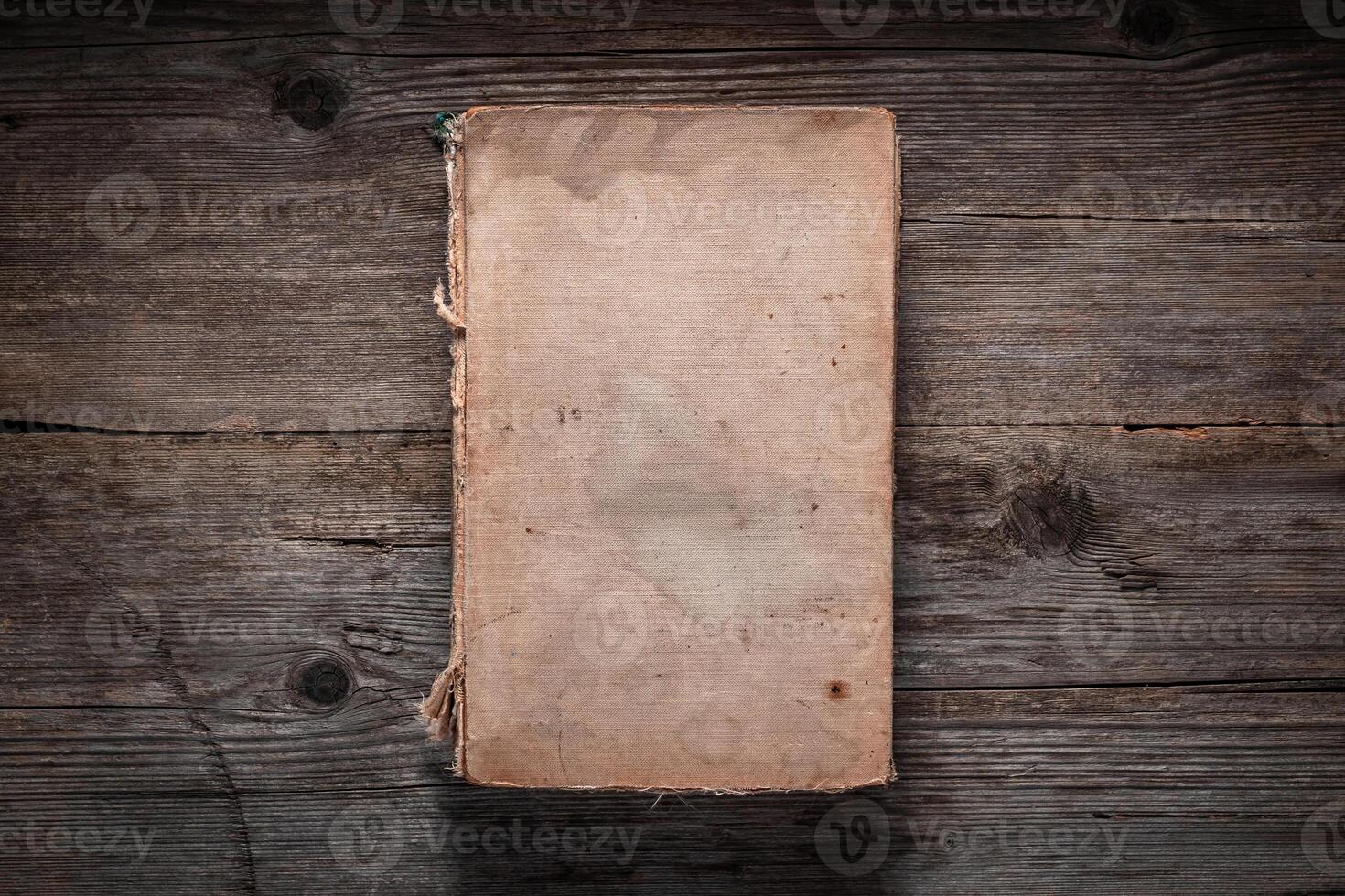 Closed book on vintage wooden background. Old book on the wooden table. Closed book with empty cover laying on wooden table. photo