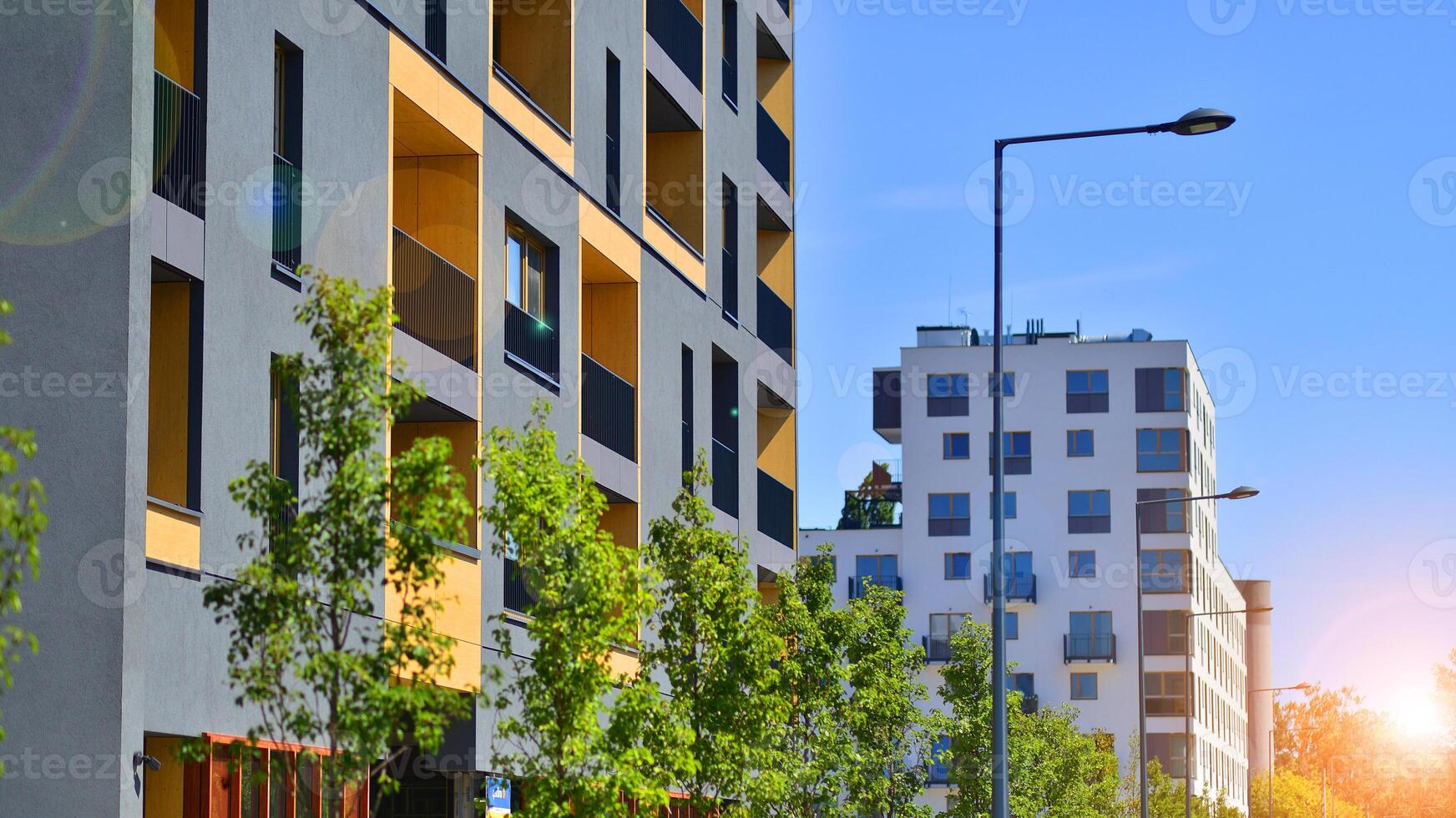 New modern block of flats in green area. Eco apartment building saving energy and fresh air concept. Green tree and new apartment building. The harmony of nature and modernity. photo