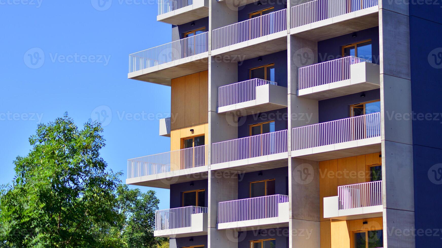 New modern block of flats in green area. Eco apartment building saving energy and fresh air concept. Green tree and new apartment building. The harmony of nature and modernity. photo