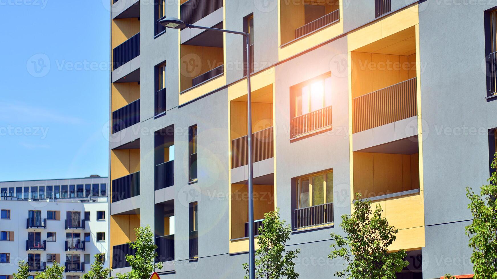 New modern block of flats in green area. Eco apartment building saving energy and fresh air concept. Green tree and new apartment building. The harmony of nature and modernity. photo