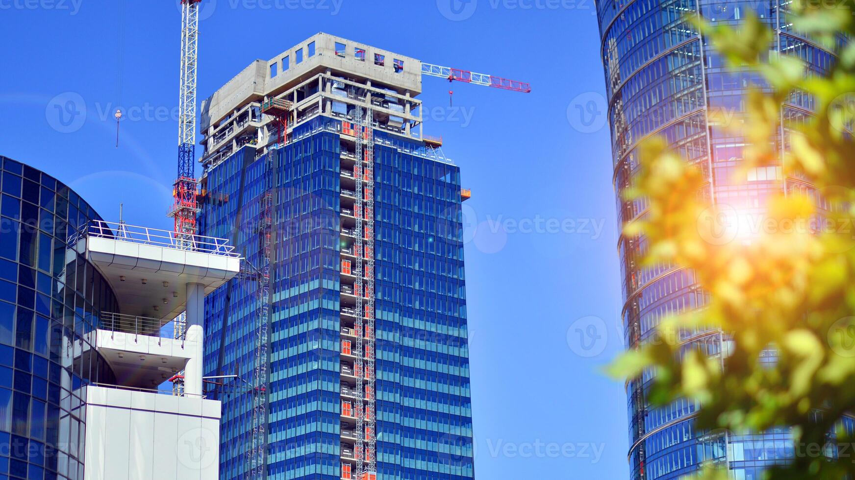 City life, urban landscape and ecology. Modern office complex with glass facades and smooth lines against backdrop of green trees, concept of modern architecture. Organically building into nature. photo