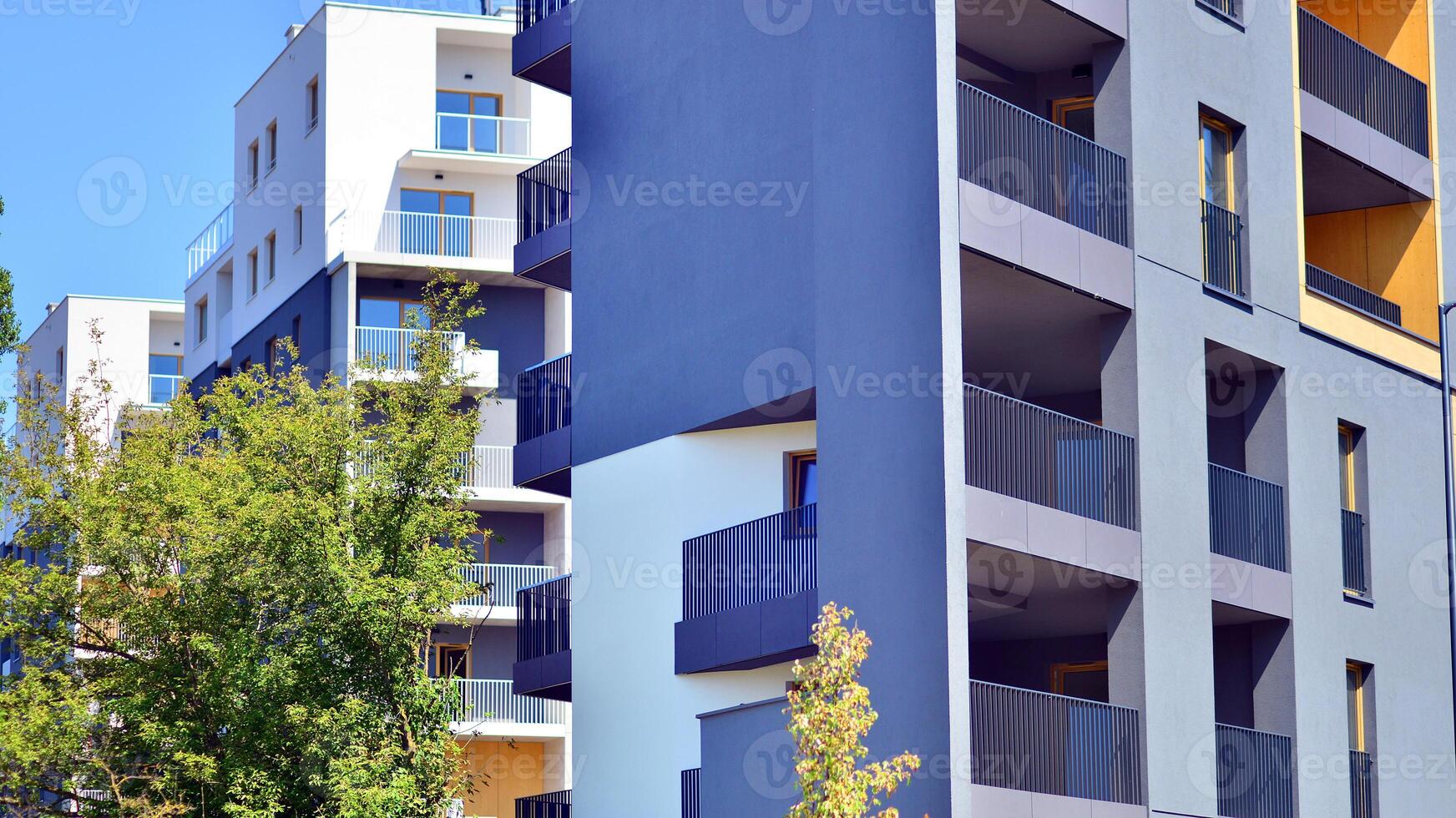 New modern block of flats in green area. Eco apartment building saving energy and fresh air concept. Green tree and new apartment building. The harmony of nature and modernity. photo