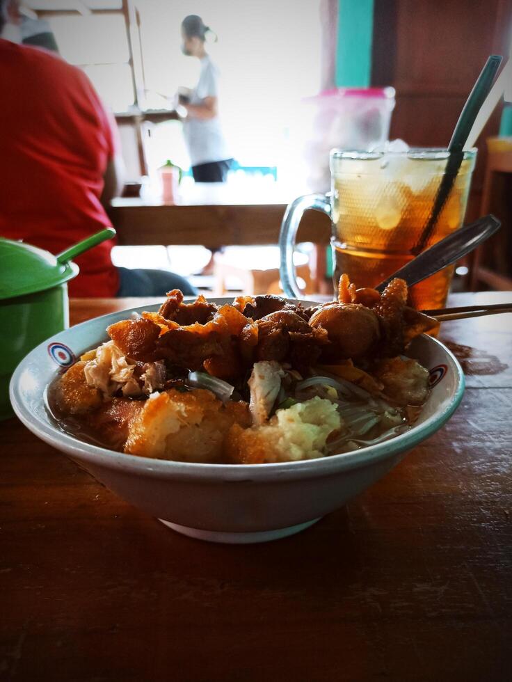 Soto ayam with chicken skin satay as a side dish is a favorite food in Indonesia photo