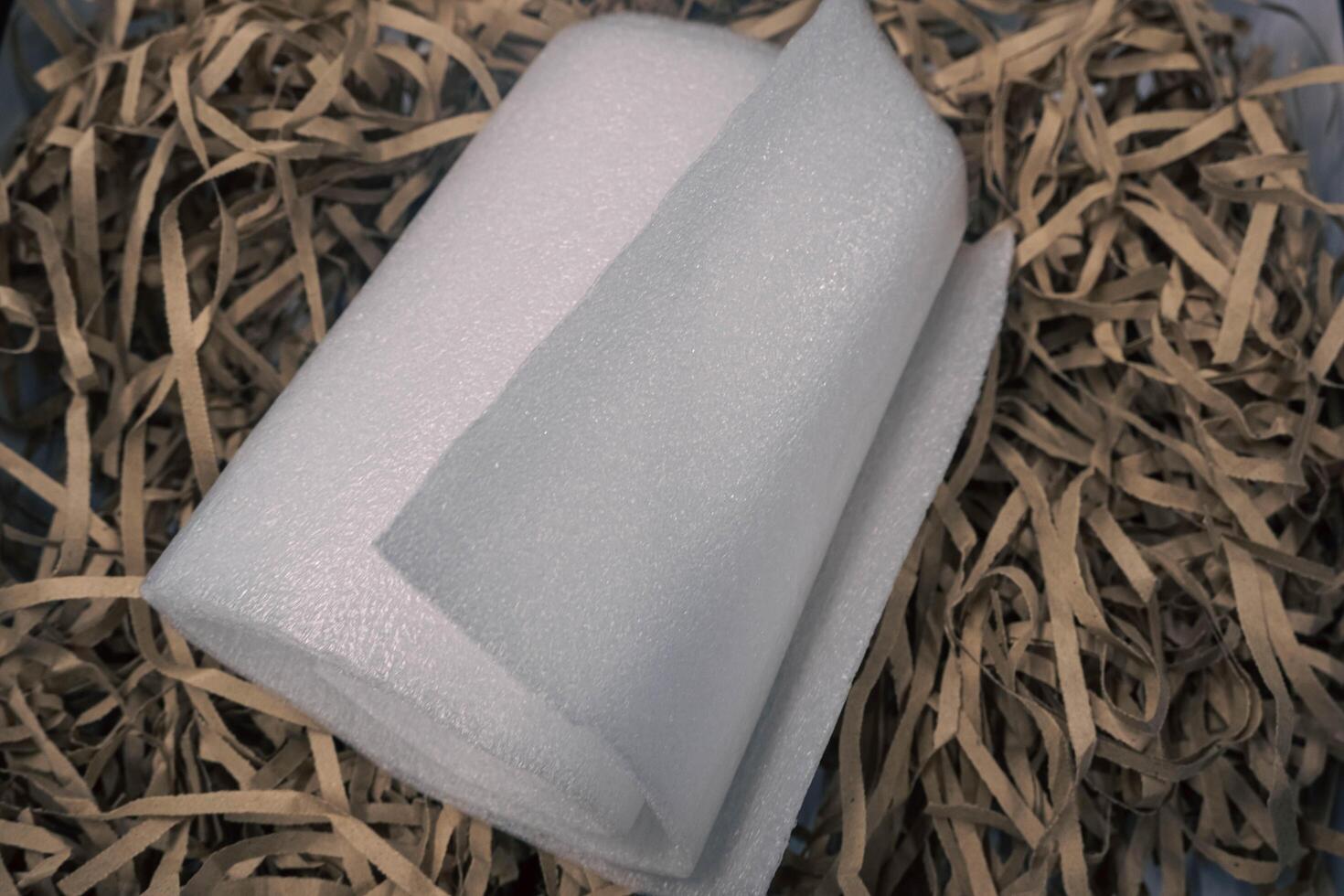 A roll of styrofoam on a piece of brown paper. photo