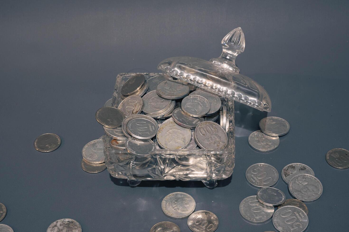 Money coins in clear glass on dark grey background, Business investment growth concept, saving concept, Coin in clear jar over dark grey background. Copy space. photo