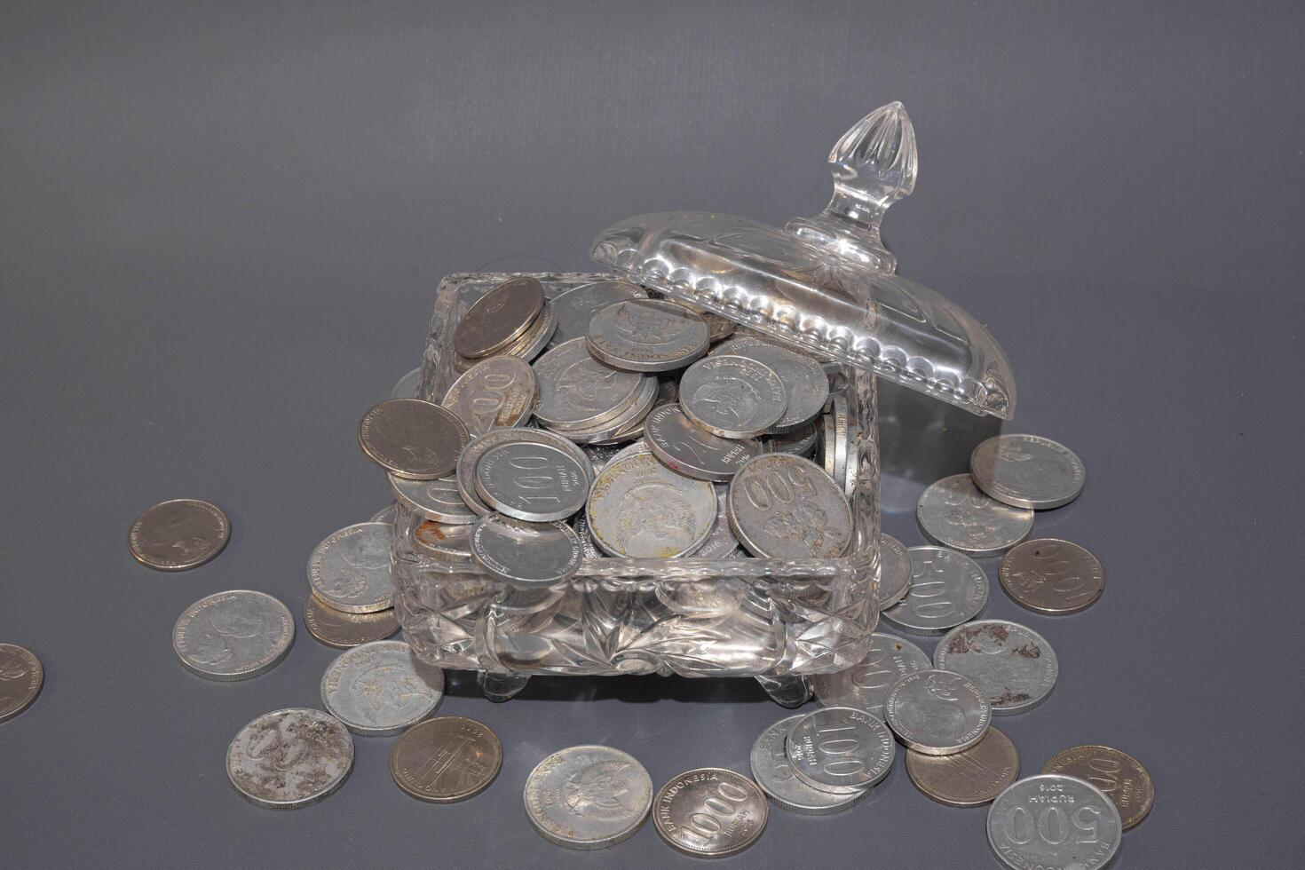 Money coins in clear glass on dark grey background, Business investment growth concept, saving concept, Coin in clear jar over dark grey background. Copy space. photo